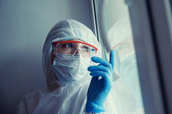 Depression syndrome in woman after quarantine of coronavirus. Lonely girl looks out window