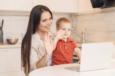 Anne ve oğlu internette aile ile görüntülü konuşma yapıyorlar. İletişim karantina insanları kavramı