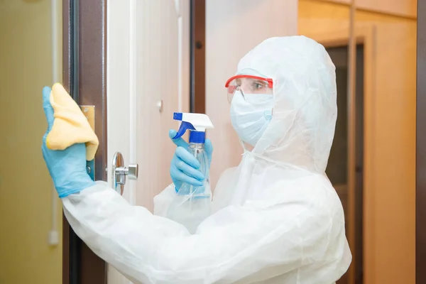 Disinfection and cleaning door handles of house from infection with virus and microbes in biochemical suit. Coronavirus protection concept — Stock Photo, Image