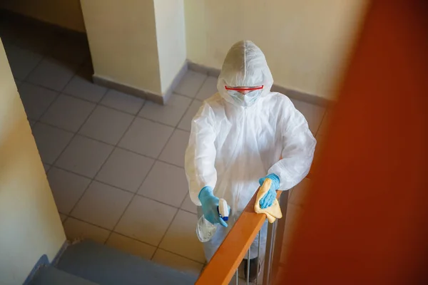 Concepto desinfección por coronavirus. Personas en materiales peligrosos haciendo limpieza en el hueco de la escalera del edificio de apartamentos —  Fotos de Stock