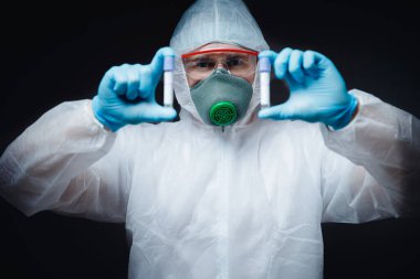 Beyaz hazmat koruyucu gözlüklü sıhhiyeci kan testi salgını koronavirüsünü aşı enjeksiyonu panzehiriyle tutuyor. Çince yeni Wuhan virüsü 2019-ncov