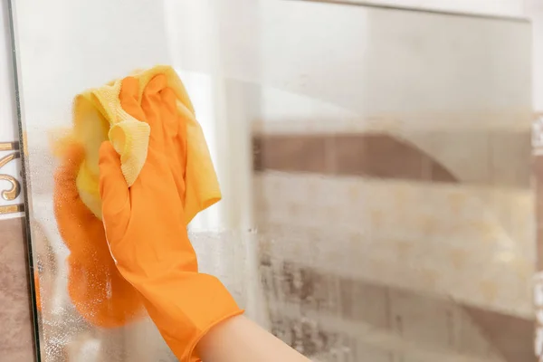 La mujer limpia el espejo de la contaminación y la placa del agua en el baño —  Fotos de Stock