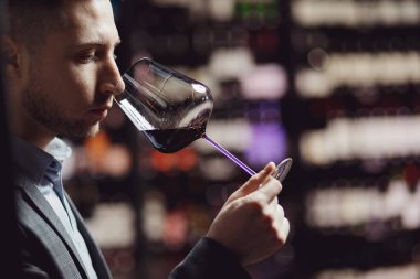 Şarap uzmanı şarap garsonu aromayı ve restoranın tadını hissediyor.