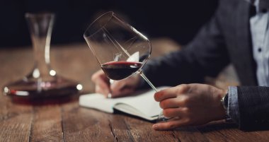 Sommelier erkekleri kırmızı şarap tatma kartı taşır.