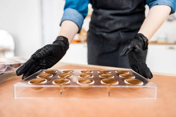 Chef o cioccolatiere Scuote gli stampi al cioccolato per dolci — Foto Stock