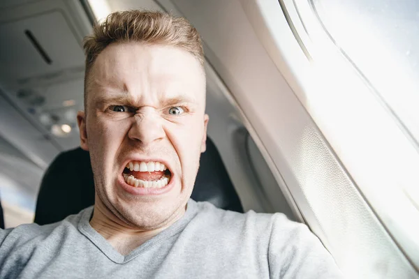 El hombre está enojado en avión antes de la salida. Retraso de aeronaves conceptuales — Foto de Stock