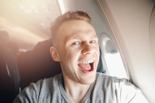 Glad turist man gör selfie foto i kabinen flygplan före avgång. Resebegrepp — Stockfoto