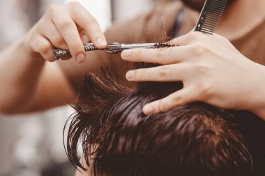 Klasik tonlama, usta berber hippi adama saç yapıyor.