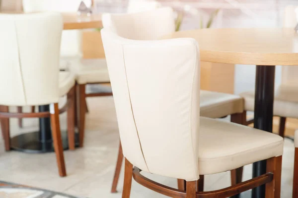 Bílé židle s dřevěnou konstrukcí v interiérové restauraci — Stock fotografie