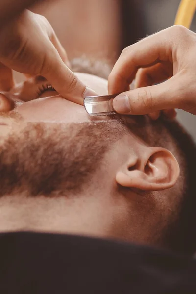 Uomo Barbiere barba rasata del cliente sulla sedia Barbiere — Foto Stock