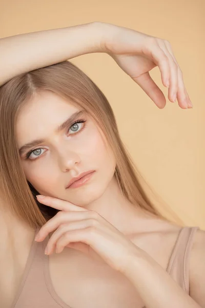 피부가 깨끗하고 배경 이 베이지 색인 아름다운 금발 소녀의 수직 사진. 미모 관리 - 패션의 개념을 마주 한다 — 스톡 사진