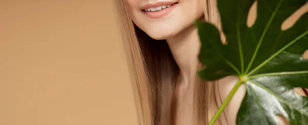 입으로 돌보는 치아와 잇몸 . 자연적 인 녹색 잎을 가진 여성, 웃는 금발의 모델 소녀 — 스톡 사진