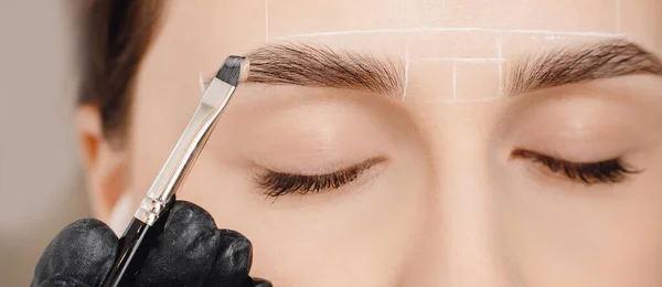 Korrektur und Augenbrauen färben, Meister trägt Pinsel auf Frau Markierung auf der Braue. Kosmetische Eingriffe Kurpflege — Stockfoto
