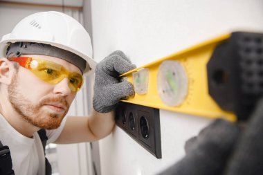 Elektrikçi inşa eden çalışma anahtarları ve soketleri siyah renk çatı katı biçimi yükler