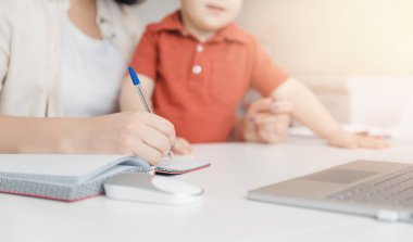 Doğum izninde olan bir kadın evde dizüstü bilgisayarla küçük bir çocukla birlikte çalışıyor. Anne kavramı, Covid-19 sırasında karantina izolasyonundayken çalışıyor.