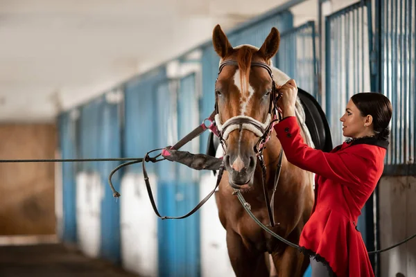 Femme cavalier se préparant à monter à cheval à travers l'hippodrome — Photo