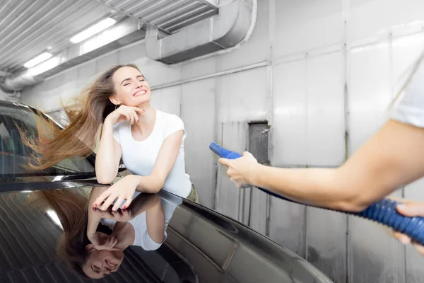 Chica trabajadora utiliza secador turbo para eliminar las gotas de agua. Servicio de lavado de coches express —  Fotos de Stock