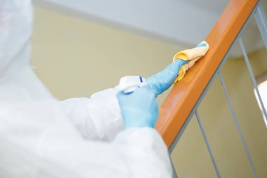 Coronavirüs dezenfeksiyonu. Tehlikeli maddeler kullanan insanlar apartmanın merdivenlerini temizliyor.