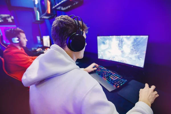 Επαγγελματίας gamer που παίζει τουρνουά σε απευθείας σύνδεση βίντεο παιχνίδια υπολογιστή με ακουστικά, κόκκινο και μπλε — Φωτογραφία Αρχείου