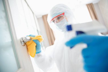 Evin dezenfeksiyon ve temizlik kapı kolları. Biyokimyasal kıyafetli mikroplar ve virüs enfeksiyonundan. Coronavirus koruma kavramı
