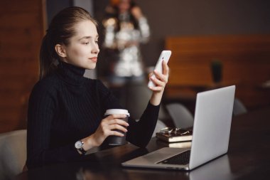 Kentteki Coronavirus yüzünden karantinaya alınırken, elleri genç bayanların internet bilgisayarındaki evlerini kahve kupalarıyla kapatıyor.