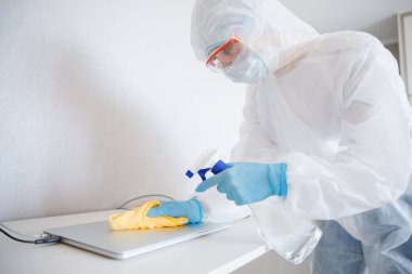 Temizlik hizmetleri ofis teknisyenlerini dezenfekte eder. Coronavirüs ve mikroplar, antiseptik işlem bilgisayarı.