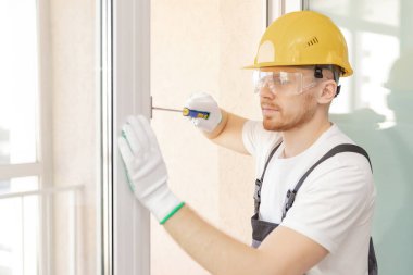 Worker in installing rubber seals on plastic upvc window clipart