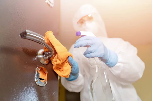 Disinfection and cleaning door handles of house from infection with virus and microbes in biochemical suit. Coronavirus protection concept — Stock Photo, Image