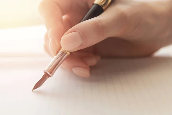 Молодая писательница пишет стихи с ручкой на листе бумаги, теплым солнечным светом — стоковое фото
