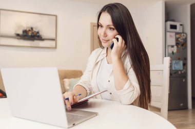 Genç kadın telefonla bağımsız blog yazarı olarak çalışıyor.