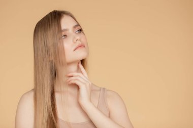 Bej rengi, soyutlanmış arka plan, cilt ve saç bakımında güzel bir portre. Güzellik yüz konsepti