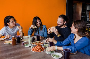Meksikalılar Meksika 'da bir Taqueria' da Tacos al Pastor yiyorlar.