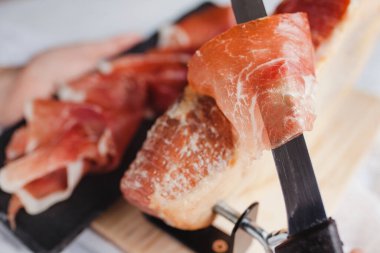 Jamon serrano. Traditional Spanish ham, Slicing of dry-cured ham in Spain