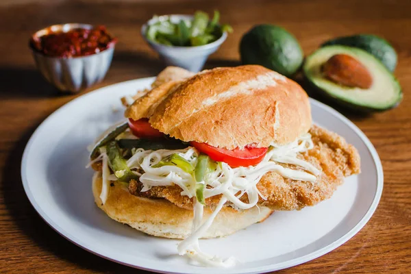 Torta mexicana es sándwich de pollo milanés con aguacate, chipotle chile y queso oaxaca —  Fotos de Stock