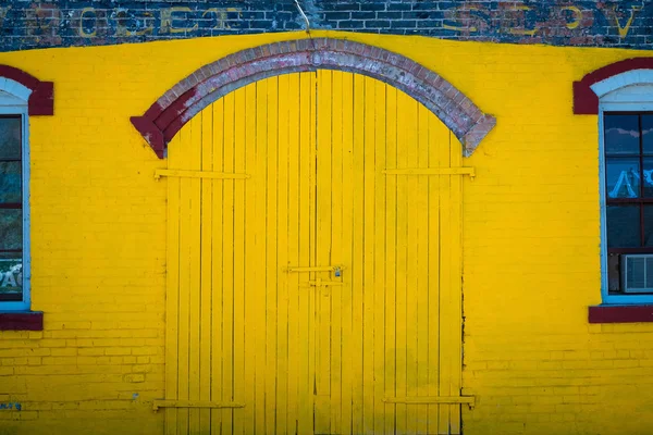 Puerta y pared de color amarillo brillante en un garaje antiguo — Foto de Stock