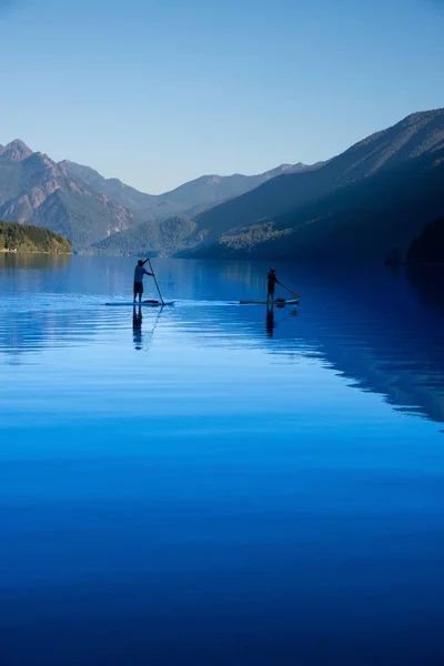 Δύο άνθρωποι paddleboarding απέναντι στη λίμνη Crescent στην Ουάσιγκτον sta — Φωτογραφία Αρχείου