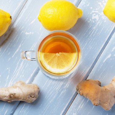 Ahşap arka plan üzerinde limonlu zencefil çay.