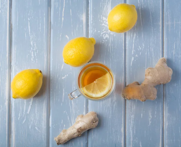 Ahşap arka plan üzerinde limonlu zencefil çay.