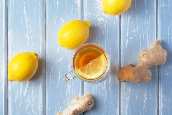 Ahşap arka plan üzerinde limonlu zencefil çay.