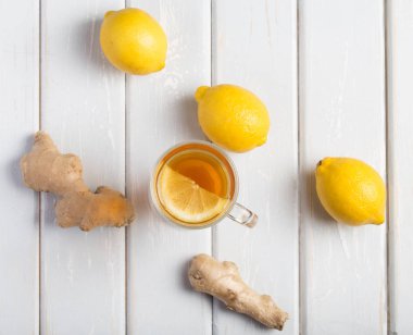 Ahşap arka plan üzerinde limonlu zencefil çay.