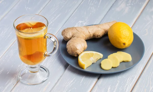 A cup of ginger tea with lemon on a wooden background. — Stock Photo, Image