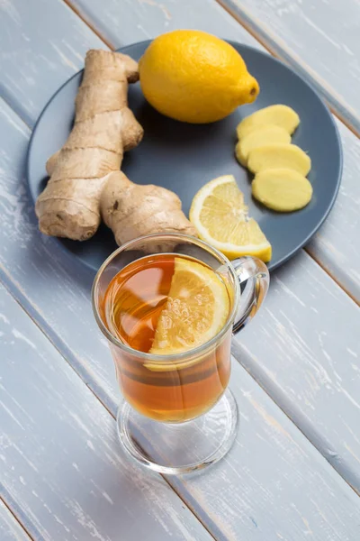 Ahşap arka plan üzerinde limonlu zencefil çay.