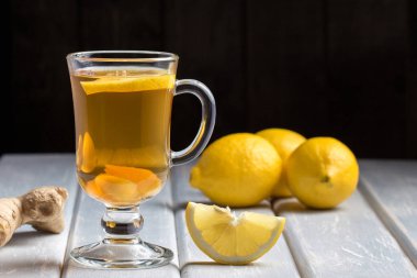 Ahşap arka plan üzerinde limonlu zencefil çay.