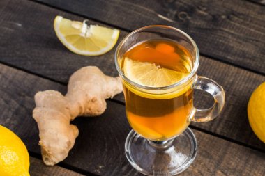 Ahşap arka plan üzerinde limonlu zencefil çay.
