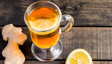 Ahşap arka plan üzerinde limonlu zencefil çay.