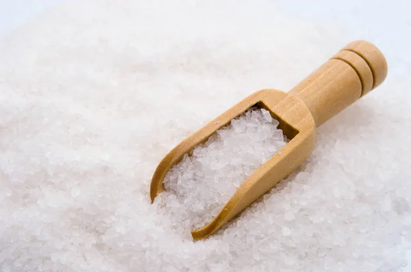 Wooden scoop on sea salt background — Stock Photo, Image