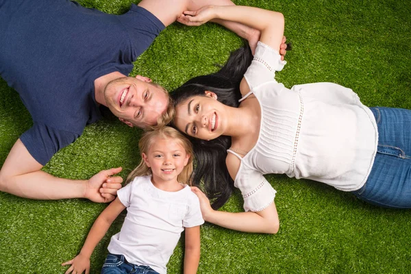 Familie liegt im Gras — Stockfoto