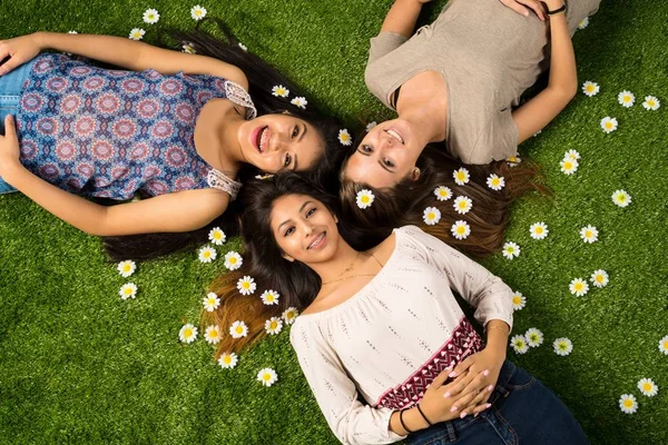 Vrienden in het gras te leggen — Stockfoto