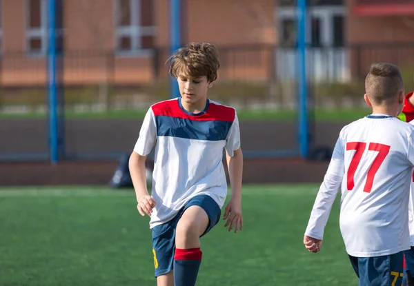 Young kids soccer football tournament - children players match on soccer field in the spring, summer