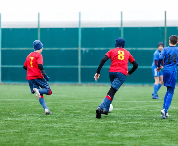 Boys Red Blue Sportswear Plays Football Field Dribbles Ball Young — Stock Photo, Image